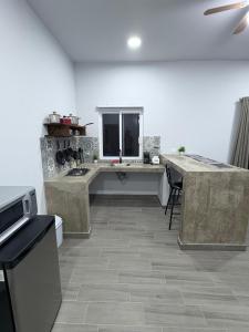 a large kitchen with a counter and a table at Los Agaves Lto in Loreto
