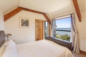a bedroom with a bed and a large window at The Stable Block Porlock Weir in Porlock