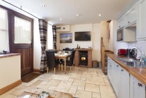 a kitchen with a table and a dining room at The Stable Block Porlock Weir in Porlock +9 photos