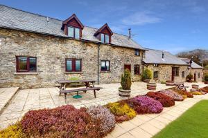 a stone house with a picnic table in front of it at Jasper Cottage Hawkridge in Dulverton