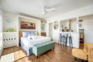 a bedroom with a white bed and a green ottoman at Oceanfront Condo, Private Patio, Beach Access, BBQ in Carlsbad