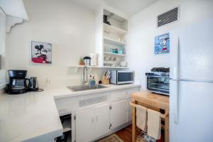 a white kitchen with a refrigerator and a microwave at Oceanfront Condo, Private Patio, Beach Access, BBQ in Carlsbad