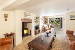 a living room with a table and a fireplace at Pebble Cottage Dunster in Dunster