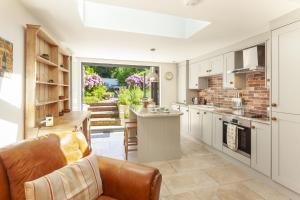 a kitchen with a couch and a table in it at Pebble Cottage Dunster in Dunster