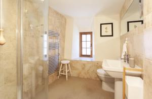 a bathroom with a shower and a toilet and a sink at Pebble Cottage Dunster in Dunster +19 photos