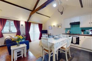 a kitchen and living room with a table and chairs at Sheepfold Cottage Dulverton in Dulverton