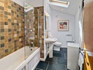 a bathroom with a tub and a sink and a toilet at St Anthonys Cottage Porlock Weir in Porlock +15 photos