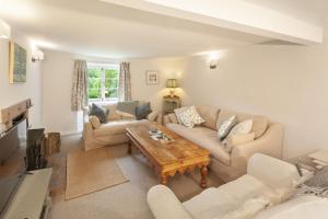 a living room with a couch and a table at Trinity Cottage Roadwater in Nettlecombe