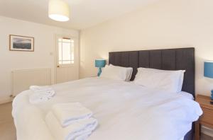 a bedroom with a large white bed with towels on it at Horner Cottage Luccombe in Minehead