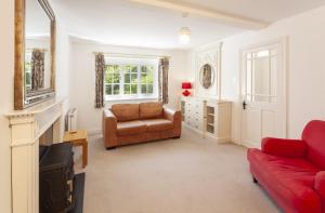 a living room with a red couch and a chair at Horner Cottage Luccombe in Minehead