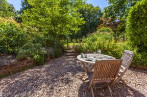 a table and two chairs in a garden at Horner Cottage Luccombe in Minehead