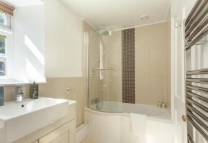 a bathroom with a tub and a sink and a shower at Horner Cottage Luccombe in Minehead +6 photos