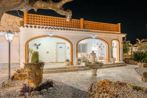 a white house with a courtyard with cacti at Finca el Placer in Ulldecona