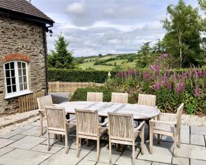 a wooden table and chairs on a patio at The Piggery Dulverton in Dulverton