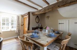 a dining room with a wooden table and chairs at The Piggery Dulverton in Dulverton
