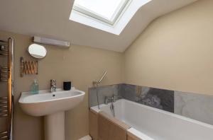 a bathroom with a sink and a bath tub and a skylight at The Piggery Dulverton in Dulverton +41 photos