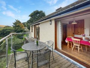 a patio with a table and chairs on a deck at Ormrods Withypool in Withypool