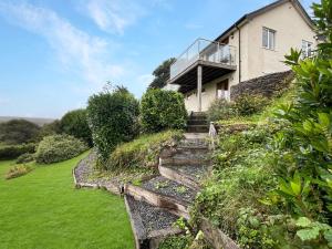 a house on a hill with stairs and a balcony at Ormrods Withypool in Withypool