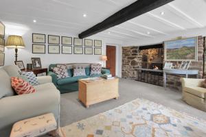 a living room with couches and a stone fireplace at Whitley Farm Molland in Molland