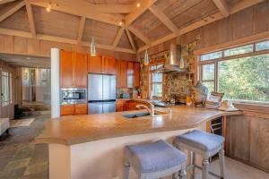 a kitchen with a sink and a counter with stools at Lighthouse in Little River +26 photos