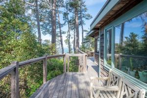a wooden deck with a chair on a house at Lighthouse in Little River