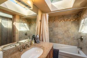 a bathroom with a sink and a tub and a mirror at Lighthouse in Little River