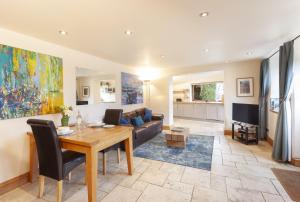 a living room with a table and a couch at The Coach House Porlock Weir in Porlock
