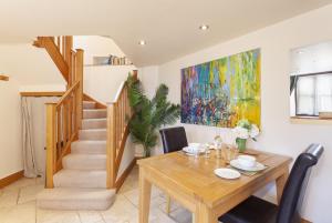 a dining room with a table and a painting at The Coach House Porlock Weir in Porlock +15 photos