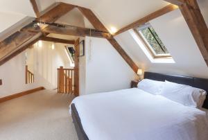 a bedroom with a white bed in a attic at The Coach House Porlock Weir in Porlock