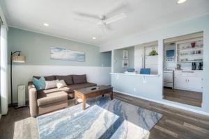 a living room with a couch and a table at Oceanfront Apartment, Private Balcony, Beach Access, Sunset Views in Carlsbad