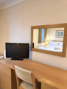a room with a desk with a television and a bed at The Inn at Emmington in Chinnor