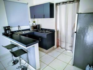 a small kitchen with a sink and a stove at Depa Colón in Mazatlán