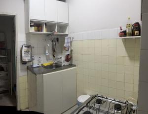 a small kitchen with a sink and a stove at Casa com ampla área externa de lazer in São Luís