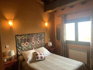 a bedroom with a large bed and a window at El Acebo de Tanarro in Sepúlveda