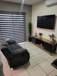 a living room with a couch and a flat screen tv at Depa Colón in Mazatlán +2 photos