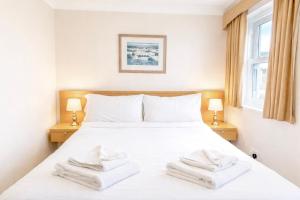a bedroom with a white bed with two towels on it at The Inn at Emmington in Chinnor