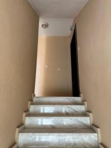 a staircase in a building with a door and a stair case at Artemis apartment in Nea Peramos
