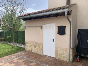 a garage with a white door in a house at El Acebo de Tanarro in Sepúlveda