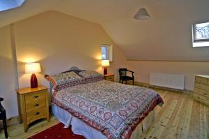 a bedroom with a bed and two tables and two lamps at 2 Bed in Maam oc-i252 in Claggan