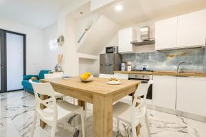 a kitchen and dining room with a wooden table and chairs at Kai Loft & Suite - By the Sea in Giardini Naxos