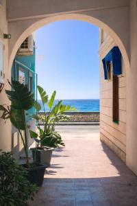 an archway with a view of the ocean from a building at Kai Loft & Suite - By the Sea in Giardini Naxos