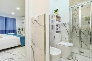 a bathroom with a shower and a toilet and a bed at Kai Loft & Suite - By the Sea in Giardini Naxos +33 photos