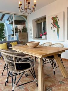 a wooden dining room table with chairs and a chandelier at Chalet Eucaliptus in Alcossebre