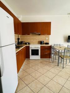 a kitchen with a table and a white refrigerator at Artemis apartment in Nea Peramos