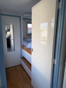a small bedroom with a bed and a mirror at Floating Hideaway in Leimuiden