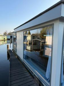 a reflection of a house in a window on a boat at Floating Hideaway in Leimuiden