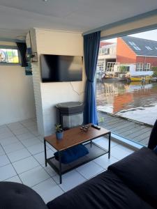a living room with a coffee table and a large window at Floating Hideaway in Leimuiden