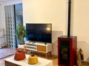 a living room with a flat screen tv and a table at Chalet Eucaliptus in Alcossebre
