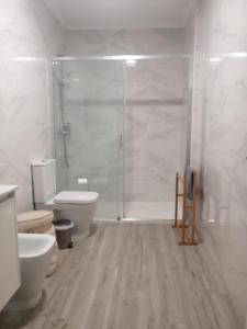 a white bathroom with a shower and a toilet at Oeste Garden Suites in Caldas da Rainha