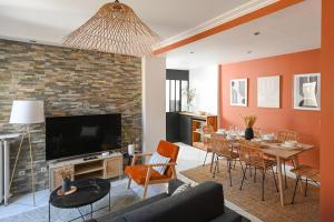 a living room with a couch and a dining room at La Belle Droite in Le Havre
